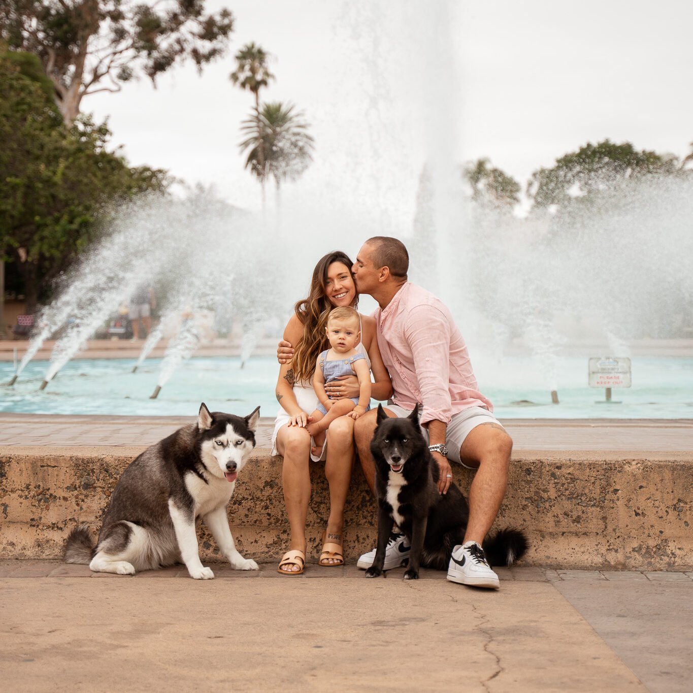 famiy sitting infront of a waterfountain in balboa park, san diego.