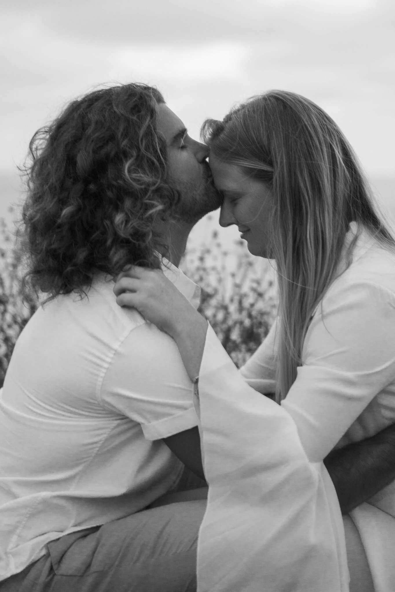 man kissinf woman on the forehead