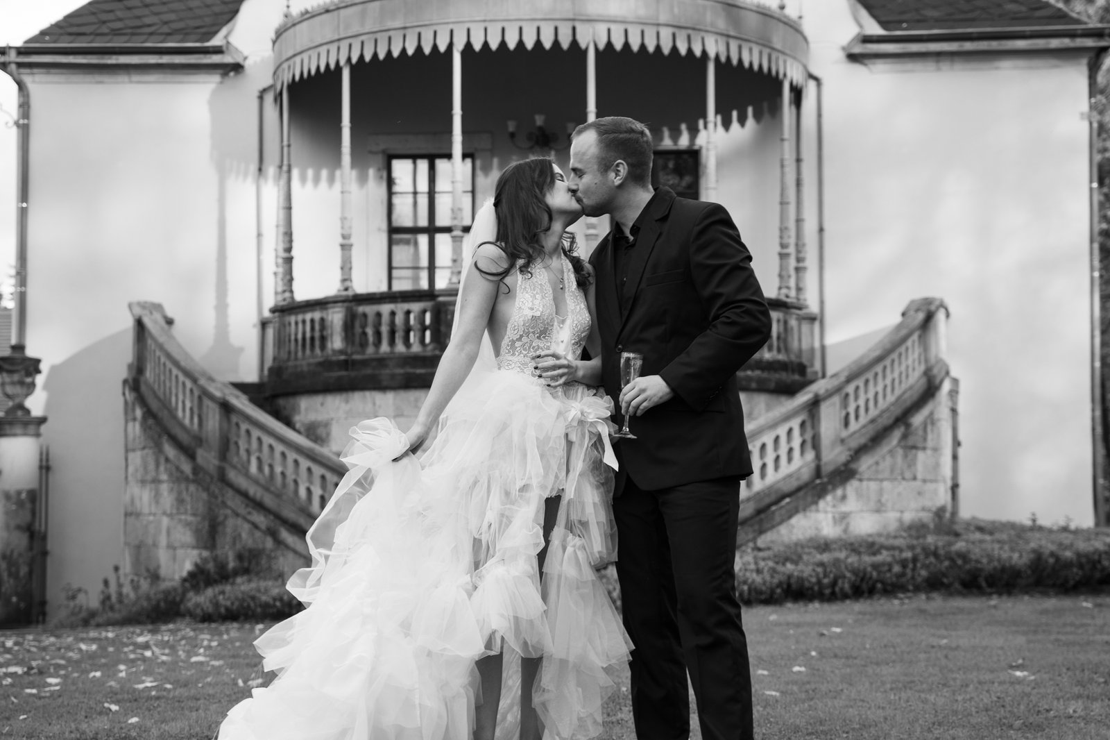 the couple standing in the middle of the castle, kissing close to each other