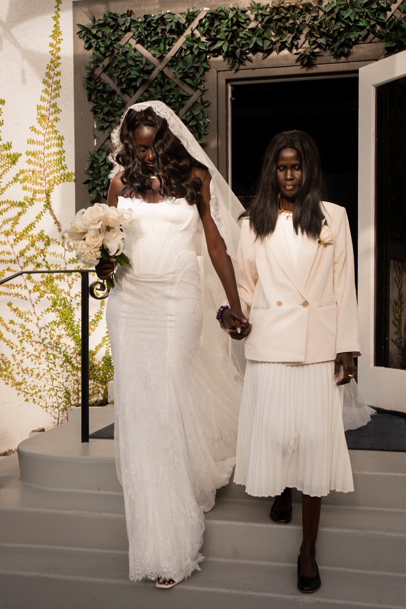 bride and her mother walking down stairs out to ceremony