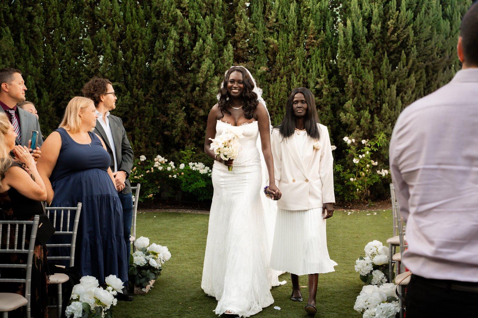 mom and bride walking down the aile