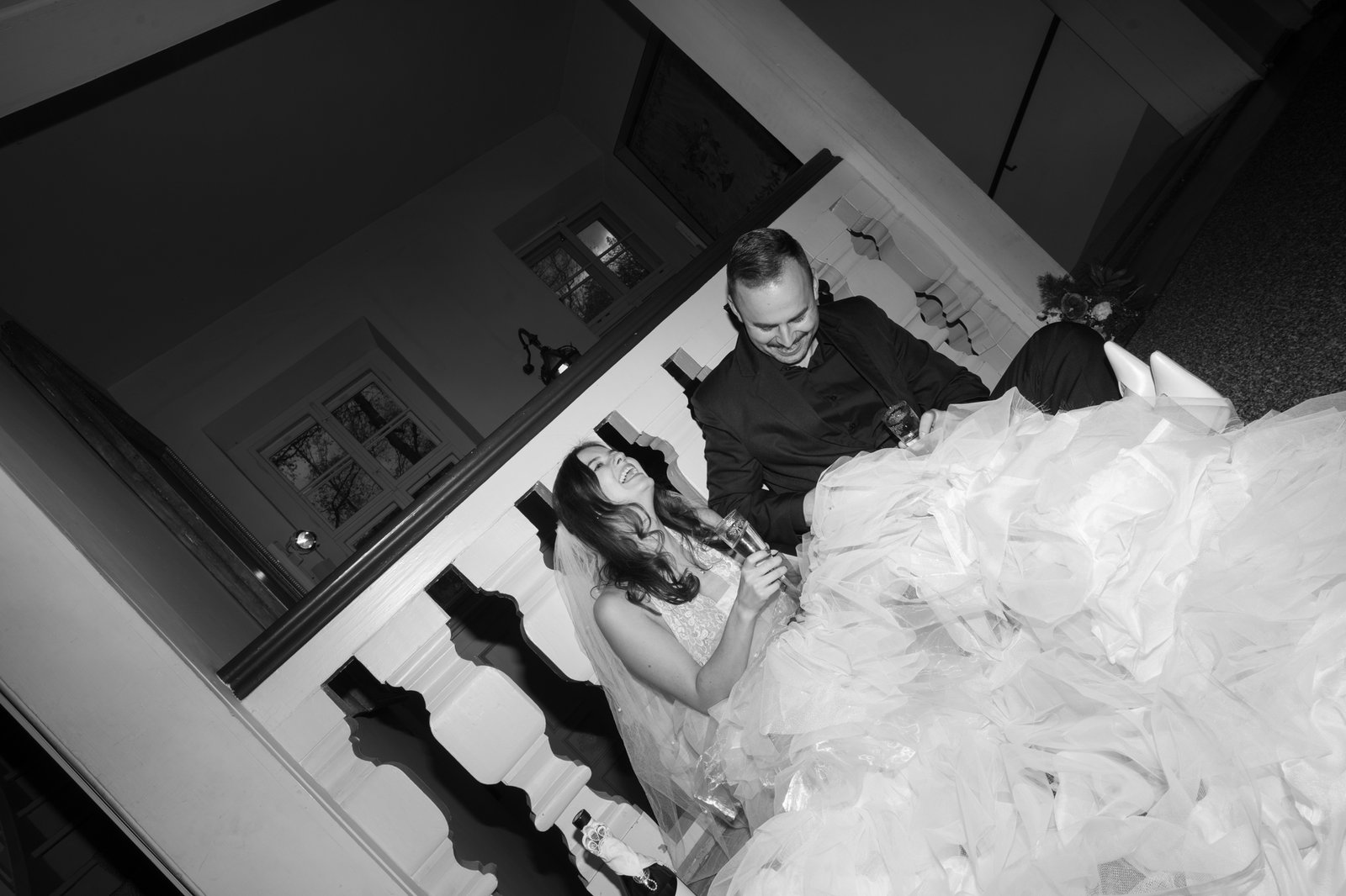 bride and groom laughing and sitting on the floor of castle
