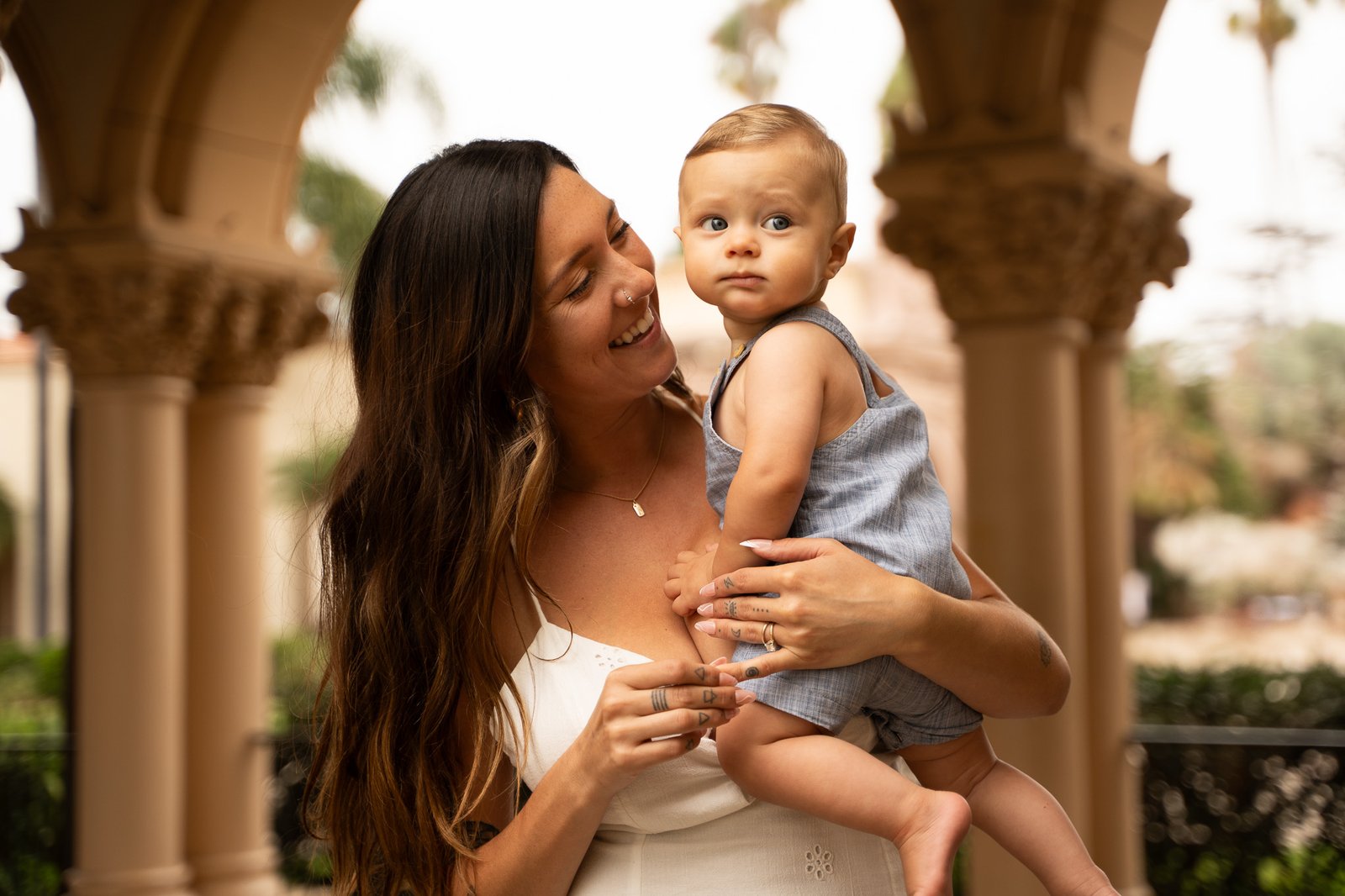 woman holding a baby, baby looking in the camera.