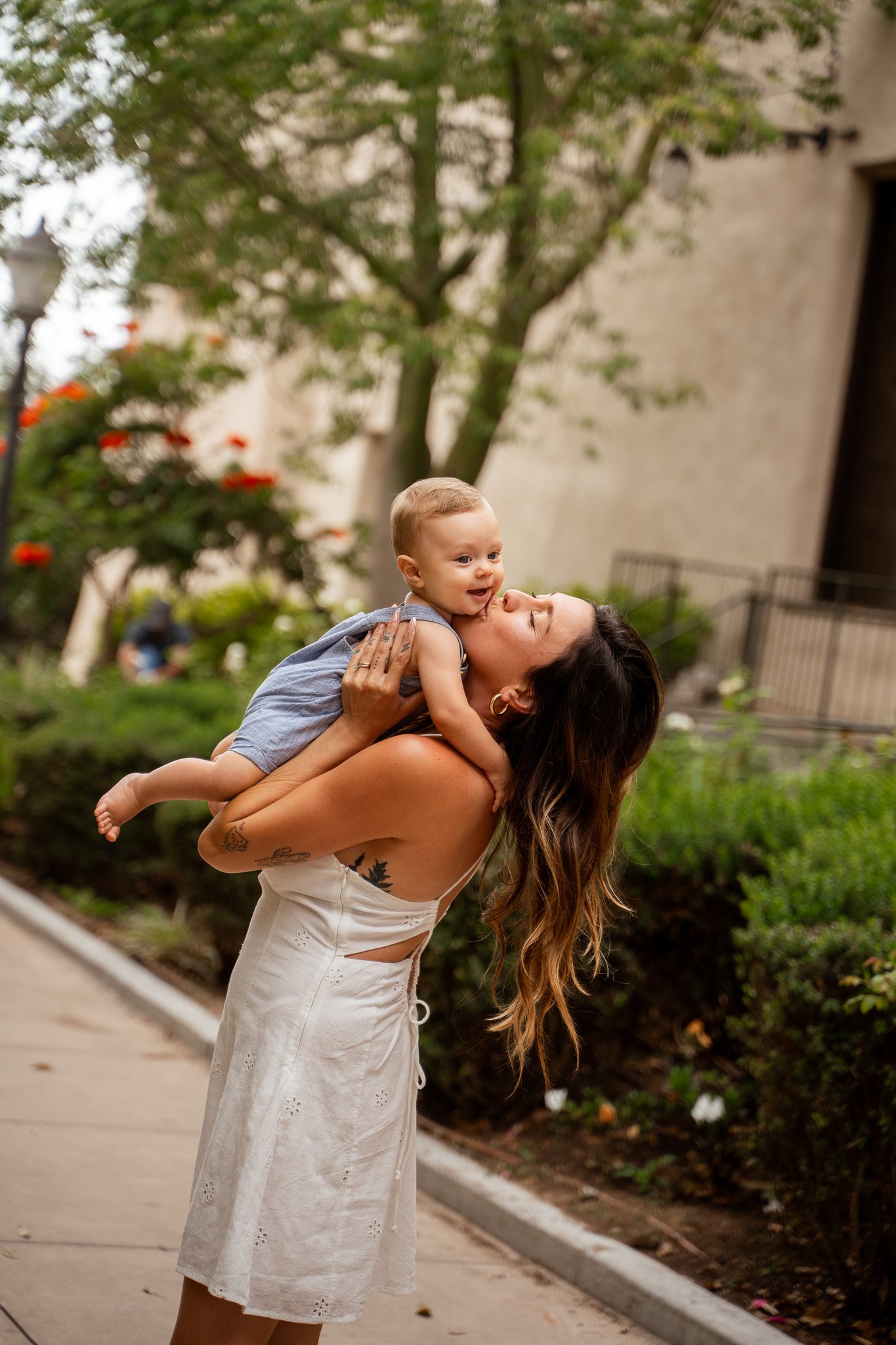 Woman holding up baby and giving him a kiss