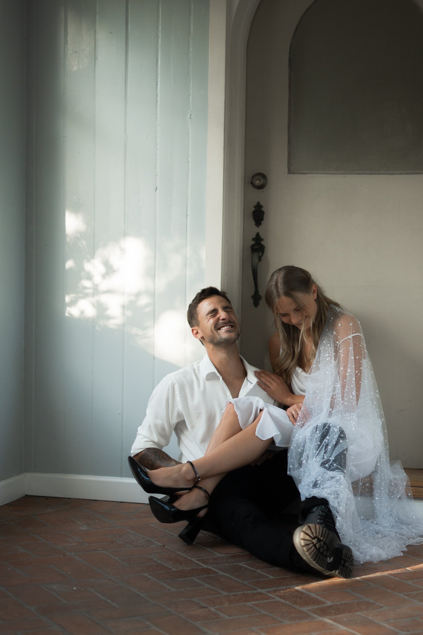 Woman and Man laughing and sitting on the floor on their weddingday