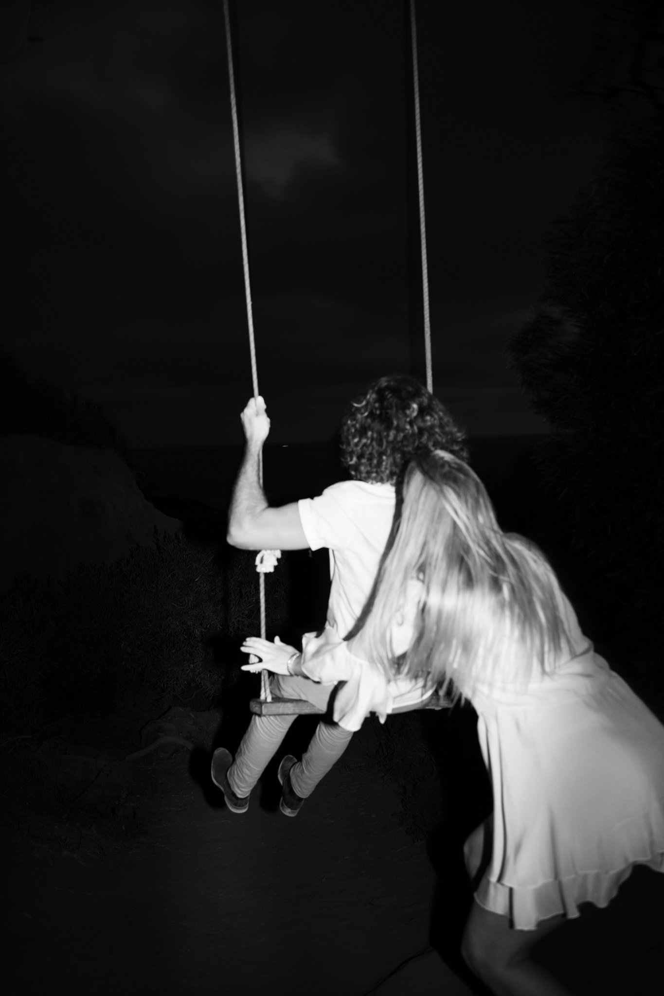 man and woman swinging on swing