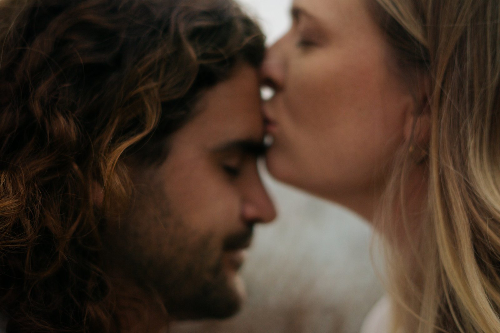 woman kissing man on forehead.