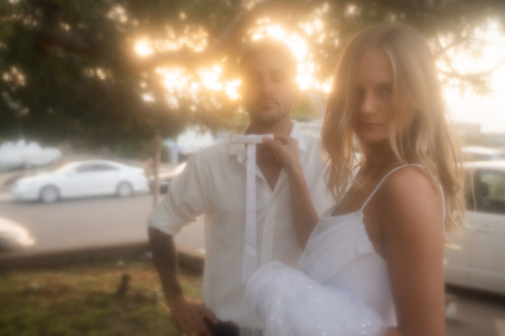 Woman holding up a tie infron of mans neck.