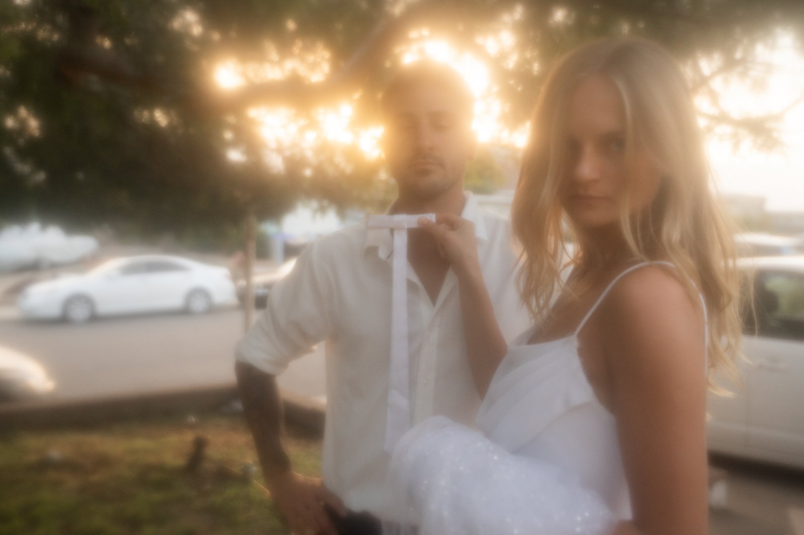 Woman holding up a tie infron of mans neck.