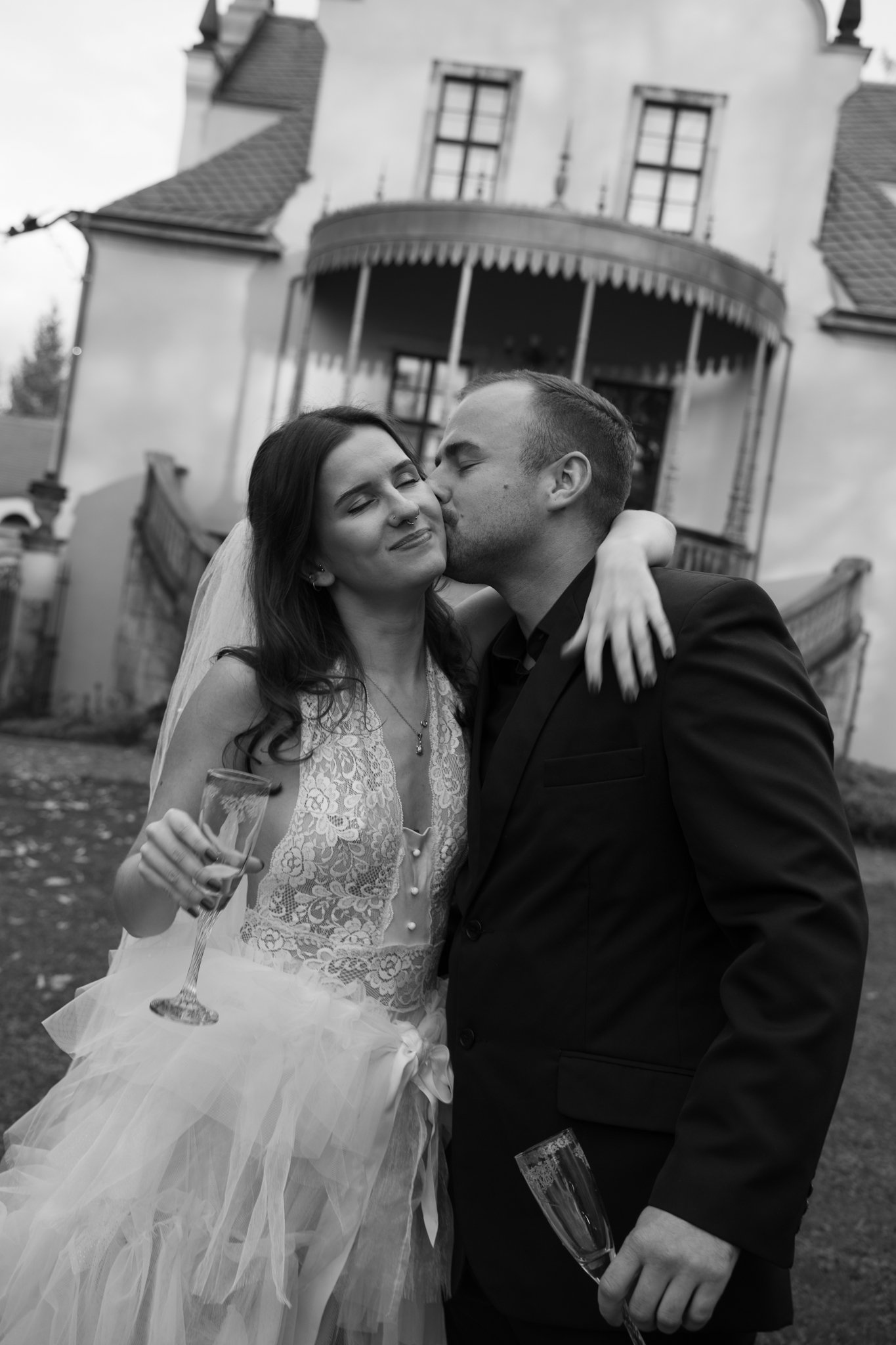 Nick is kissing Clara on her cheek, she is holding her Prosecco Glass