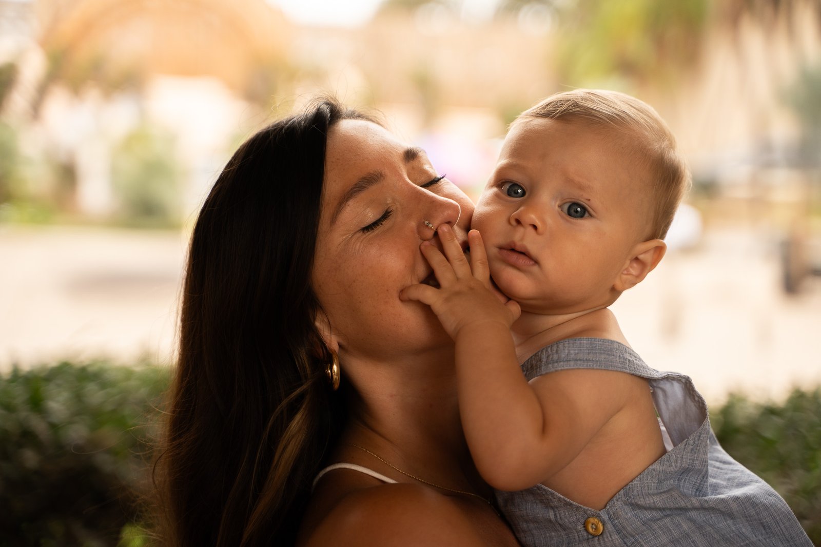 Woman hoding baby, baby is touching her.