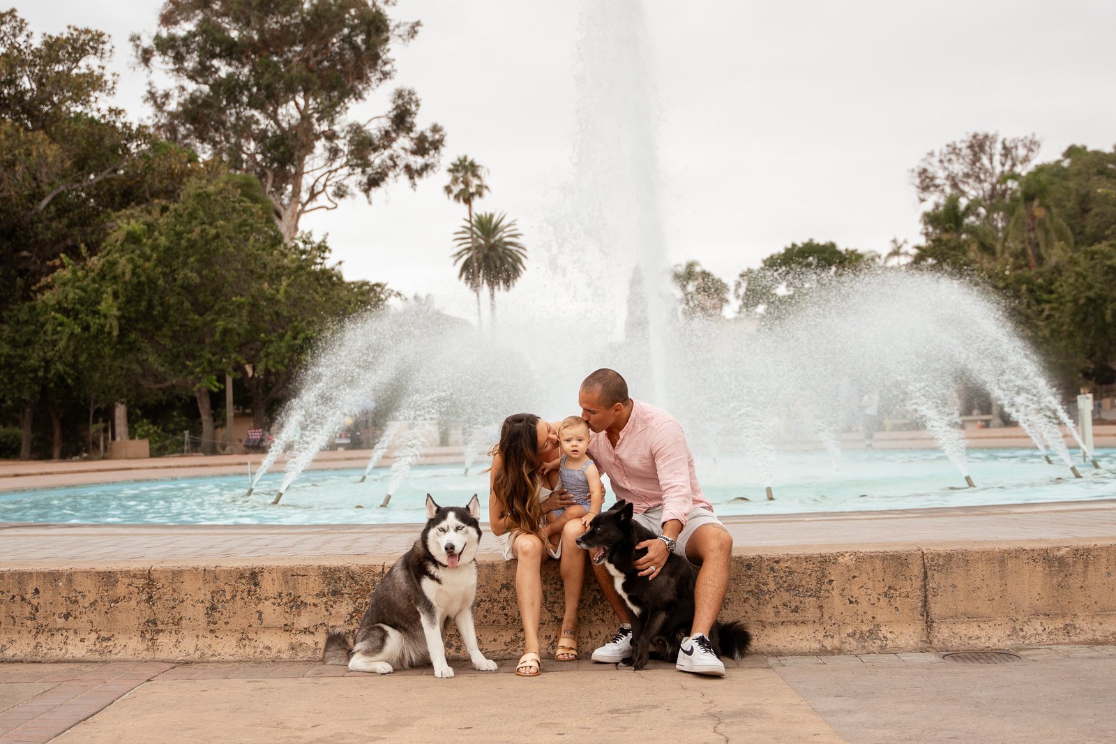 Family sitting at fountain in balboa park