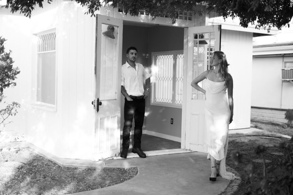 Woman and Man standing outside, MEan looking at her.