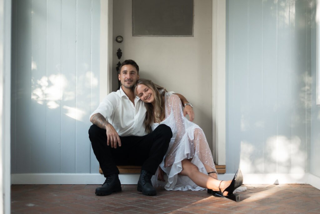Man and Woman sitting on doorstep and laughing.