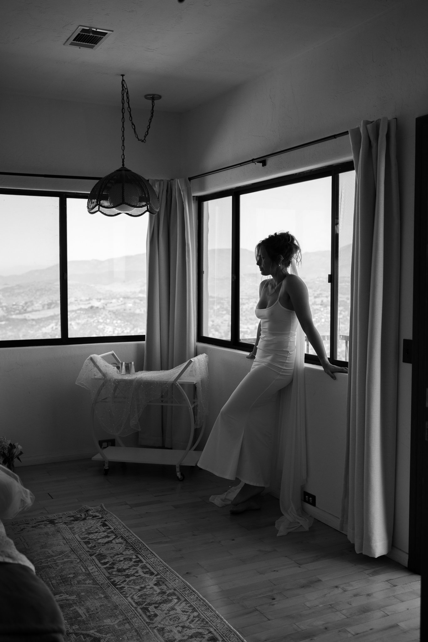 woman leaning on window black and white photo