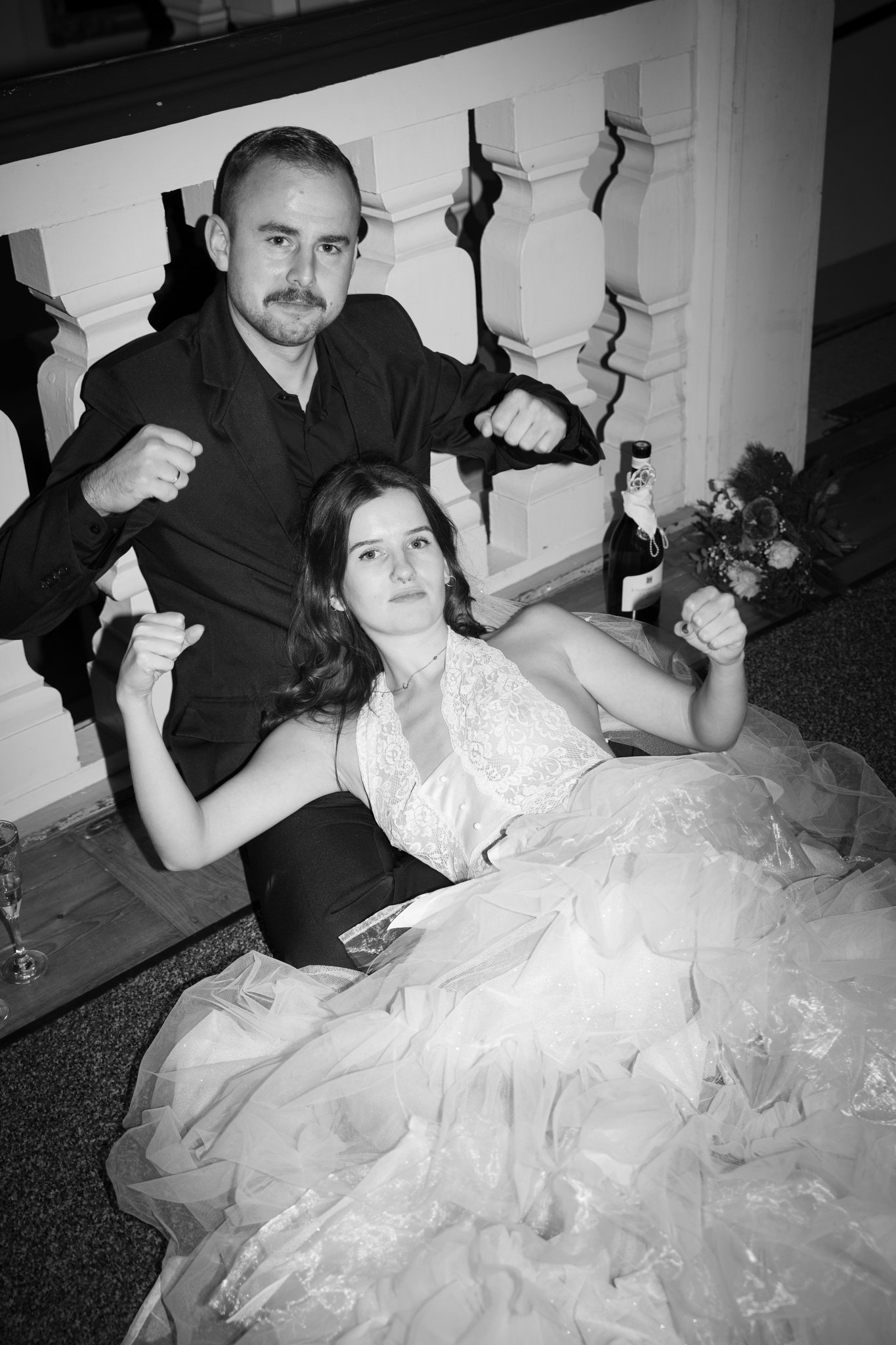 clara is laying on top of nick, both looking to the camera