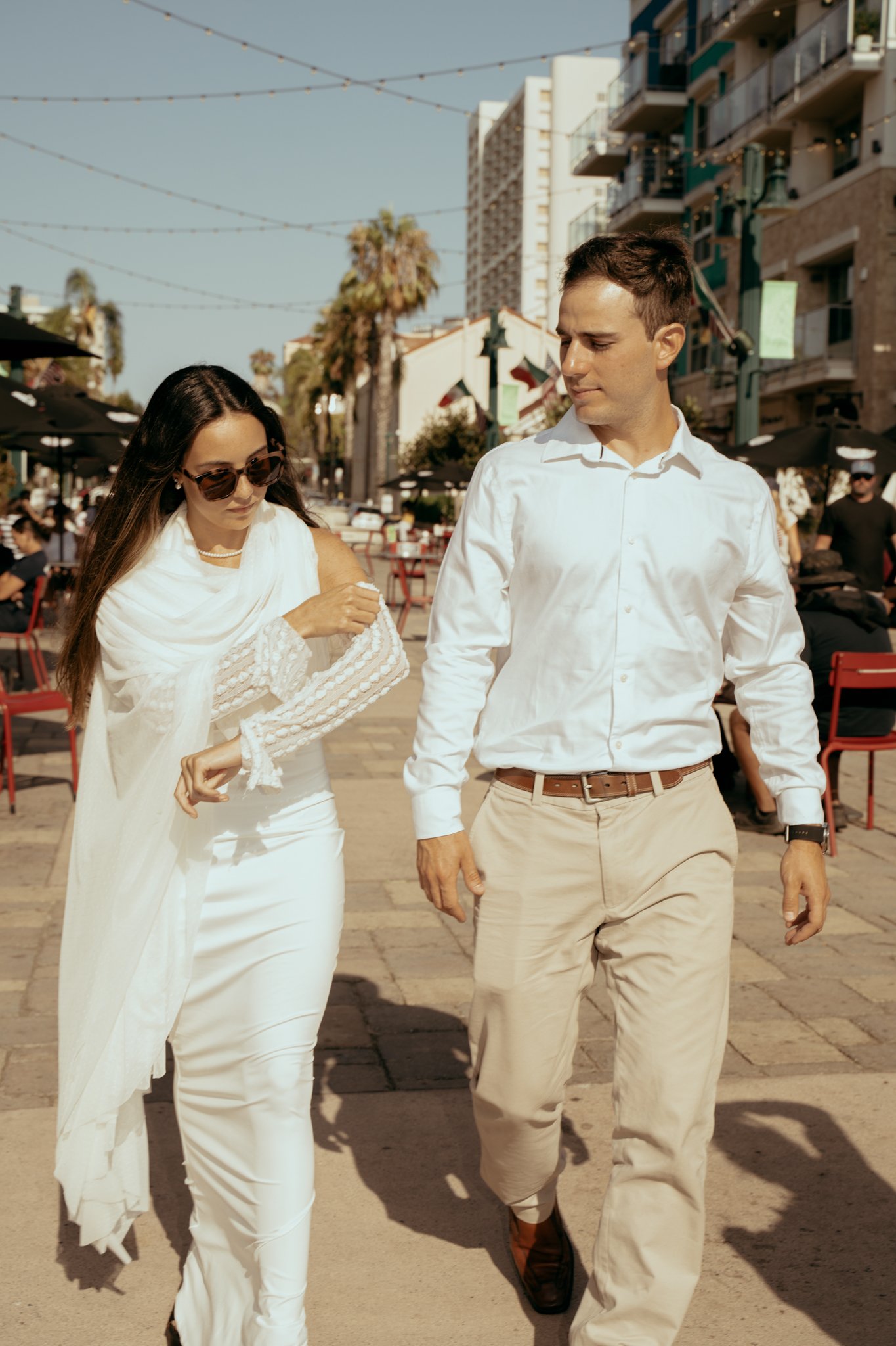 groom and bride walking down street in san diego, little italy