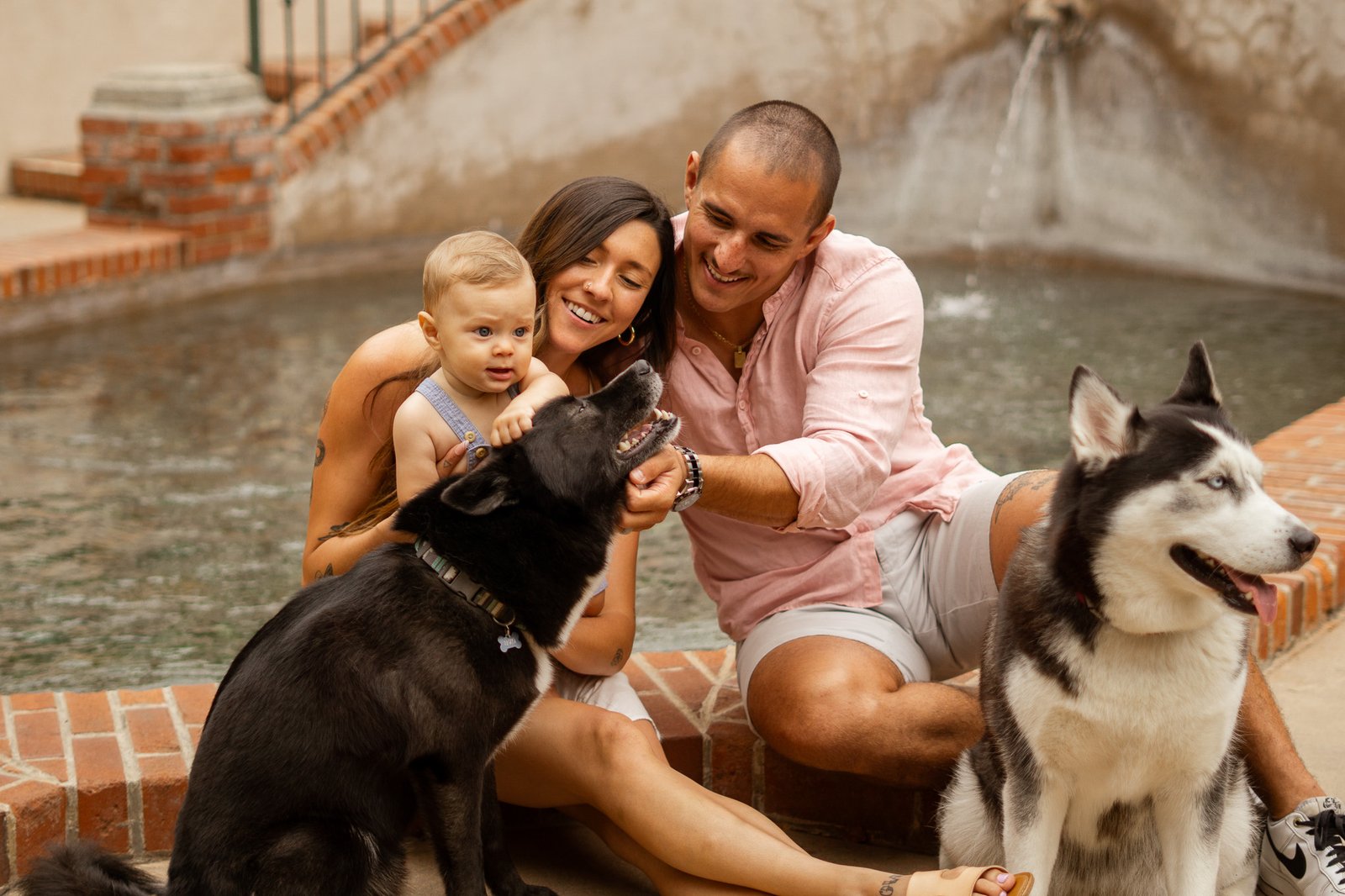 family sitting by fountain in balboa park, san diego