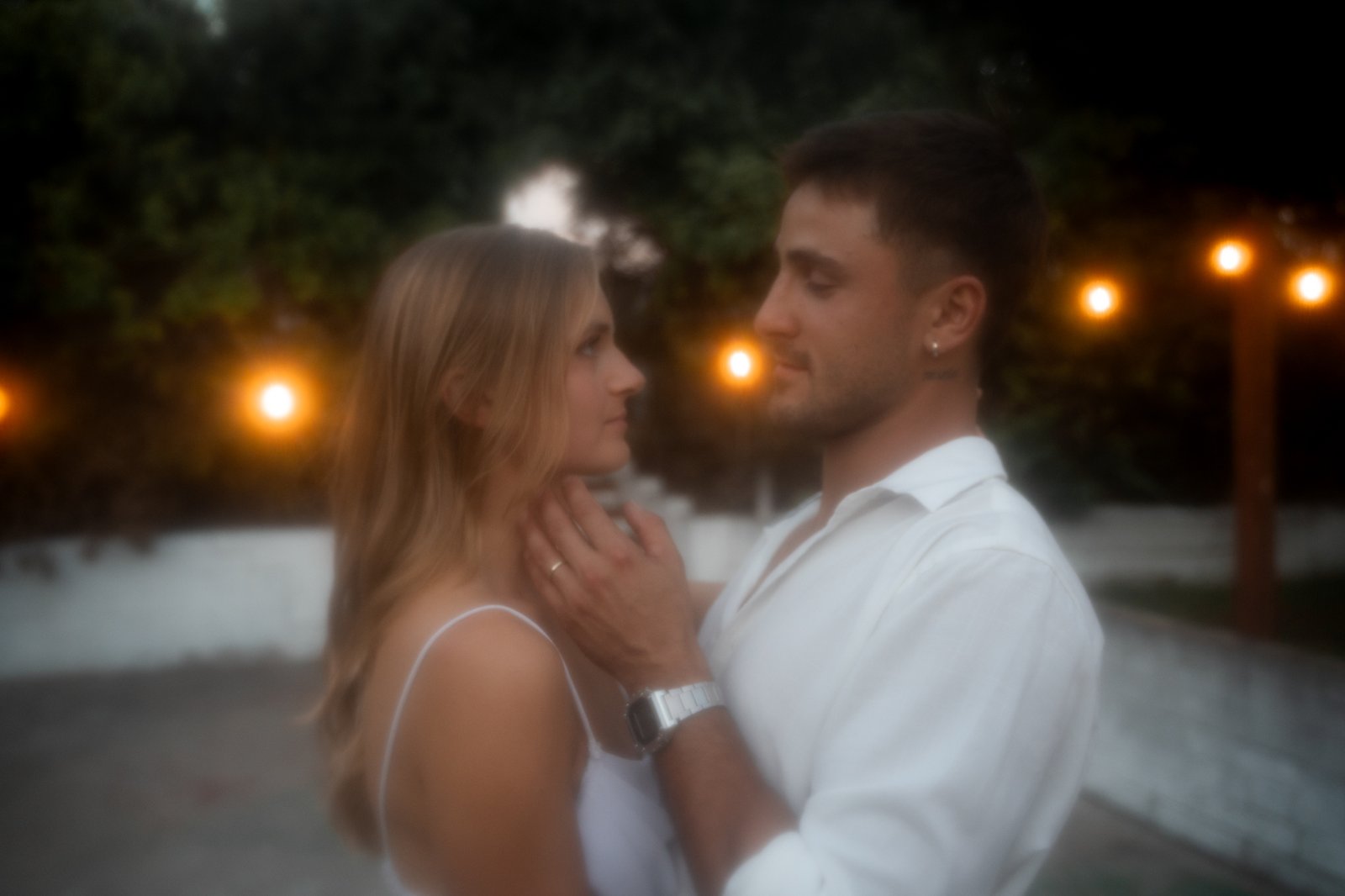 man holding womans face and looking at her.