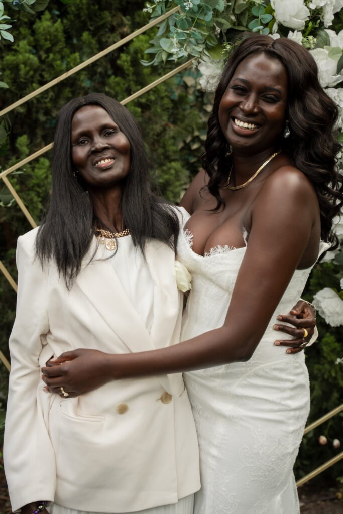 Bride and Brides Mom holding each other and looking in Camera