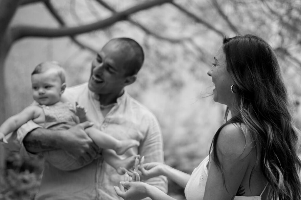 black and white family picture , mother and farther looking at baby.